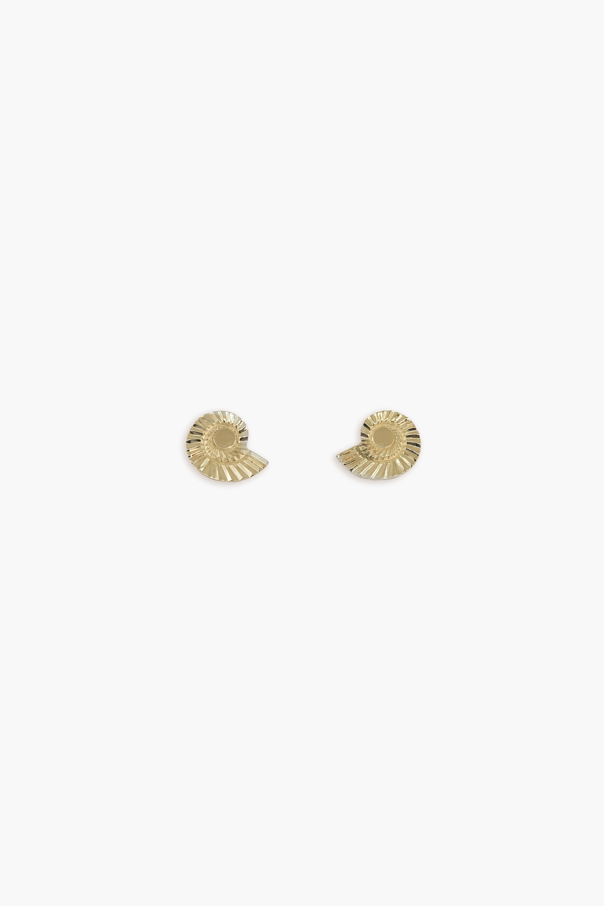 Gold earrings in the shape of a snail's shell on a white background